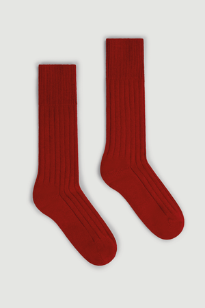 Pair of red merino ribbed bed socks on a white background