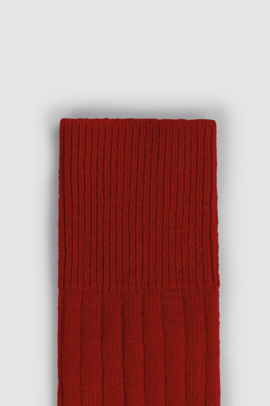 Close-up of the top of a red merino ribbed bed sock on a white background
