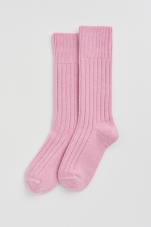 Pair of pink merino ribbed bed socks on a light grey background