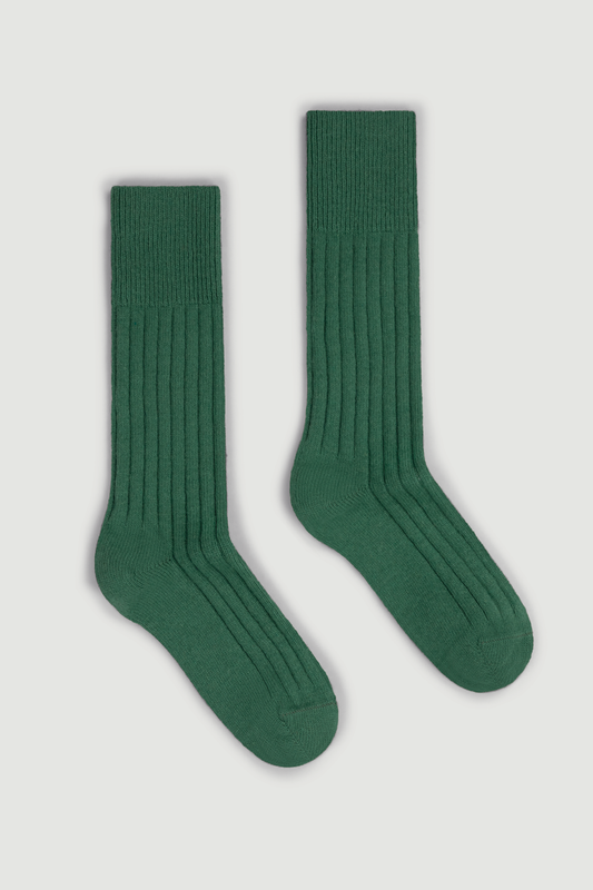 Pair of green merino ribbed bed socks on a white background