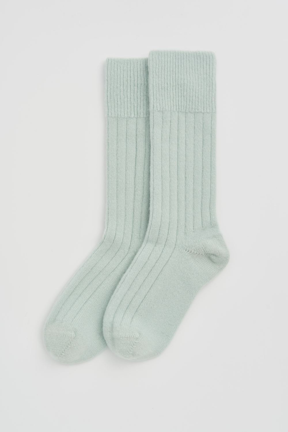 Pair of mint green merino ribbed bed socks on a white background