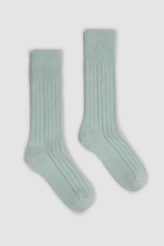 Pair of mint green merino ribbed bed socks on a white background