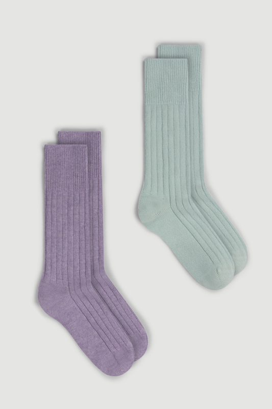 Two pairs of merino ribbed bed socks, one lilac and one mint green, on a white background.