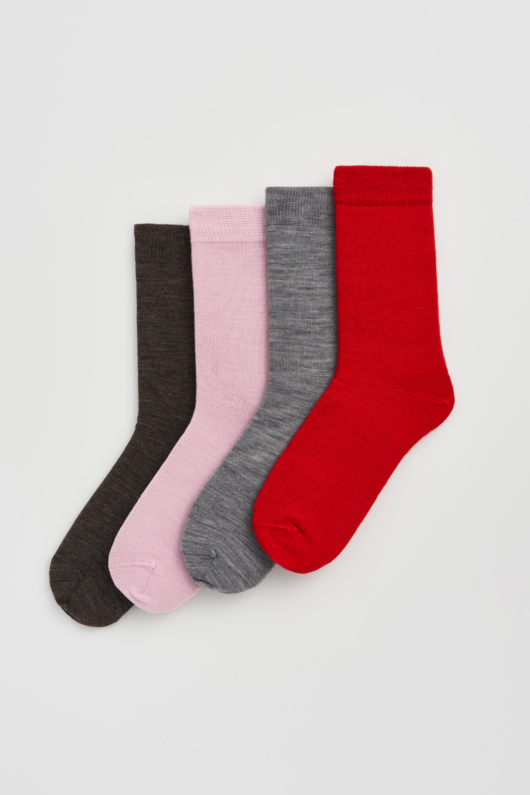 Four pairs of calf-length merino socks in dark brown, pink, grey, and red on a light grey background
