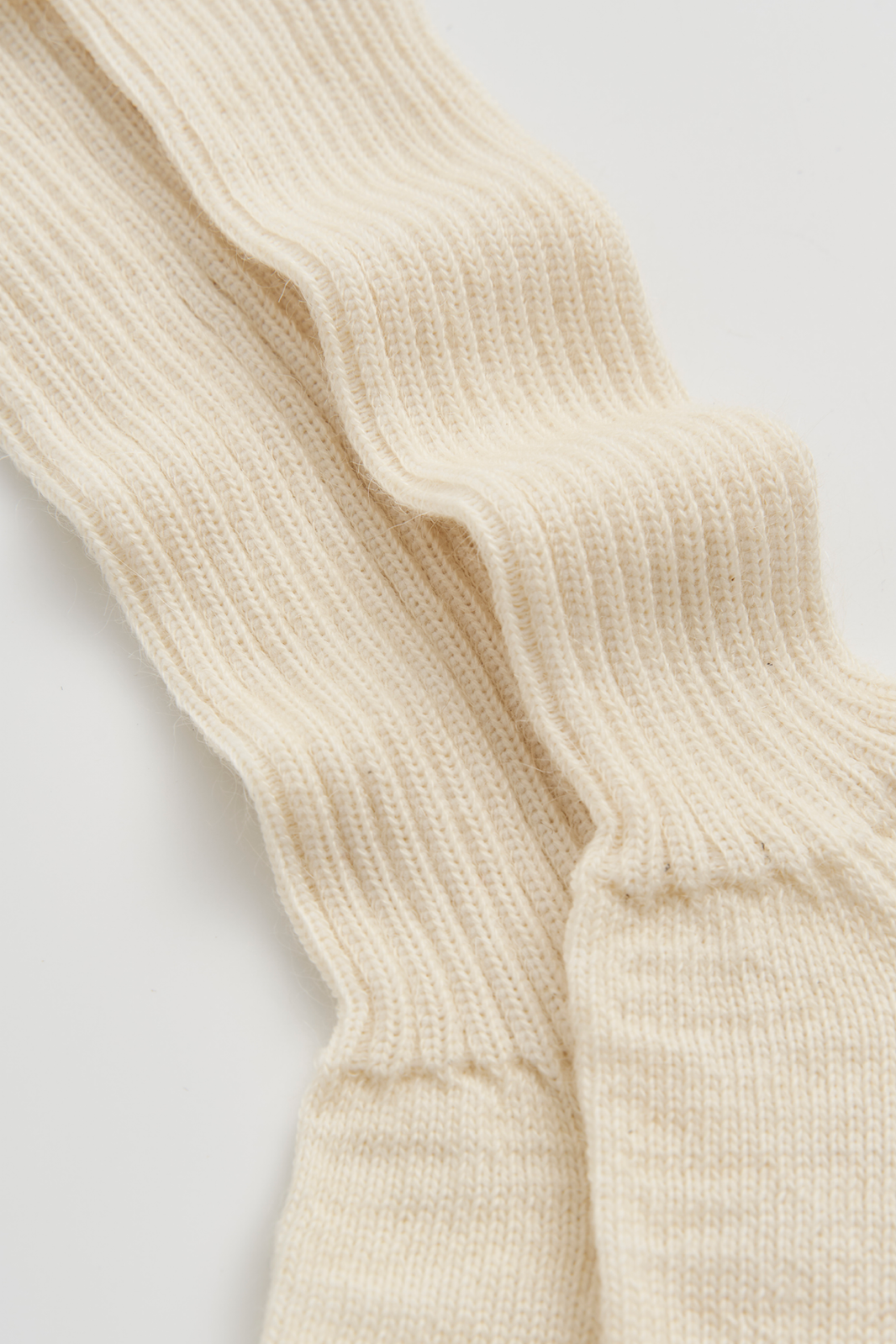 Close-up of cream ribbed mohair socks on a light background