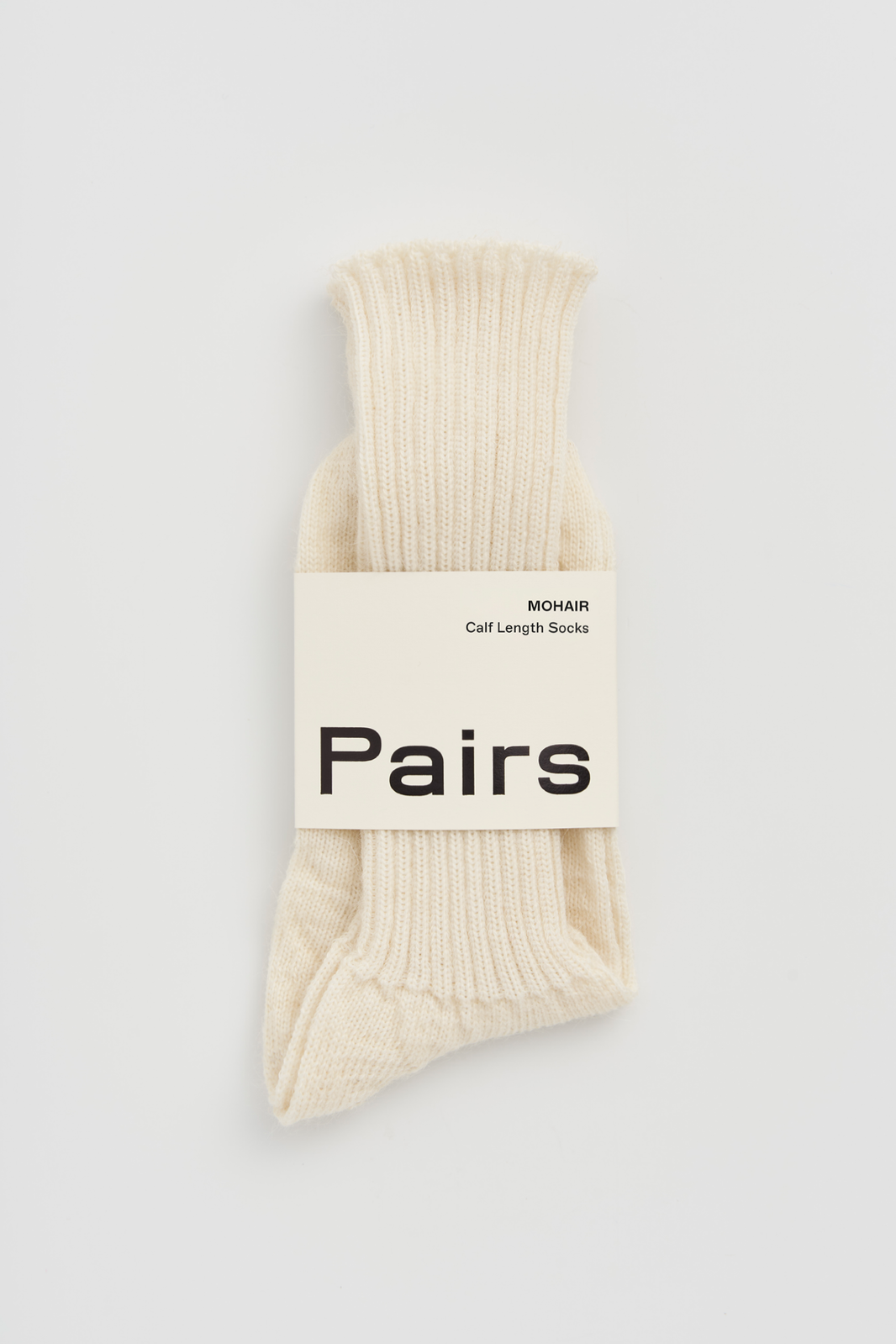 Pair of cream ribbed mohair socks with a 'Pairs' packaging band on a light grey background