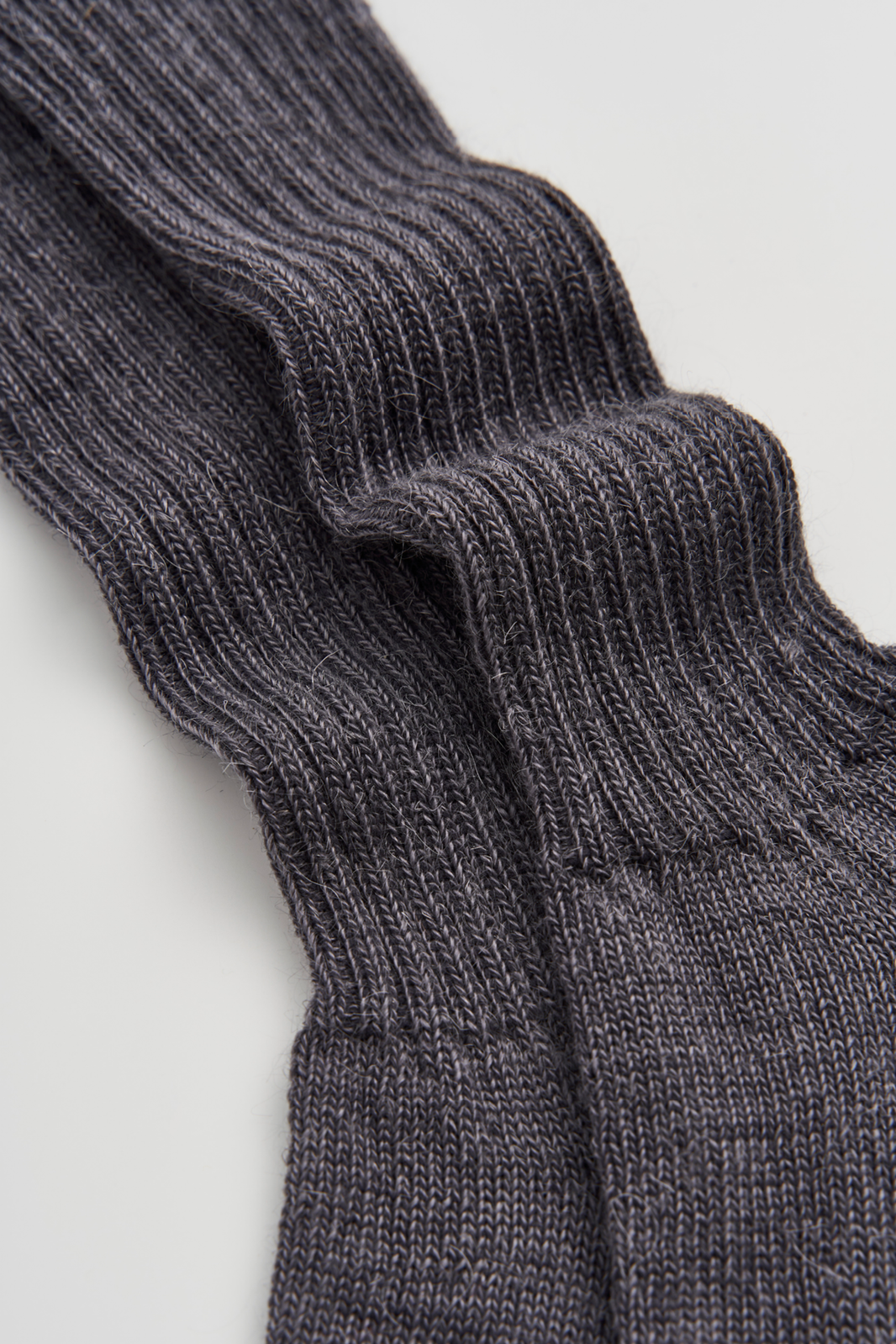 Close-up of grey ribbed mohair socks on a light grey background