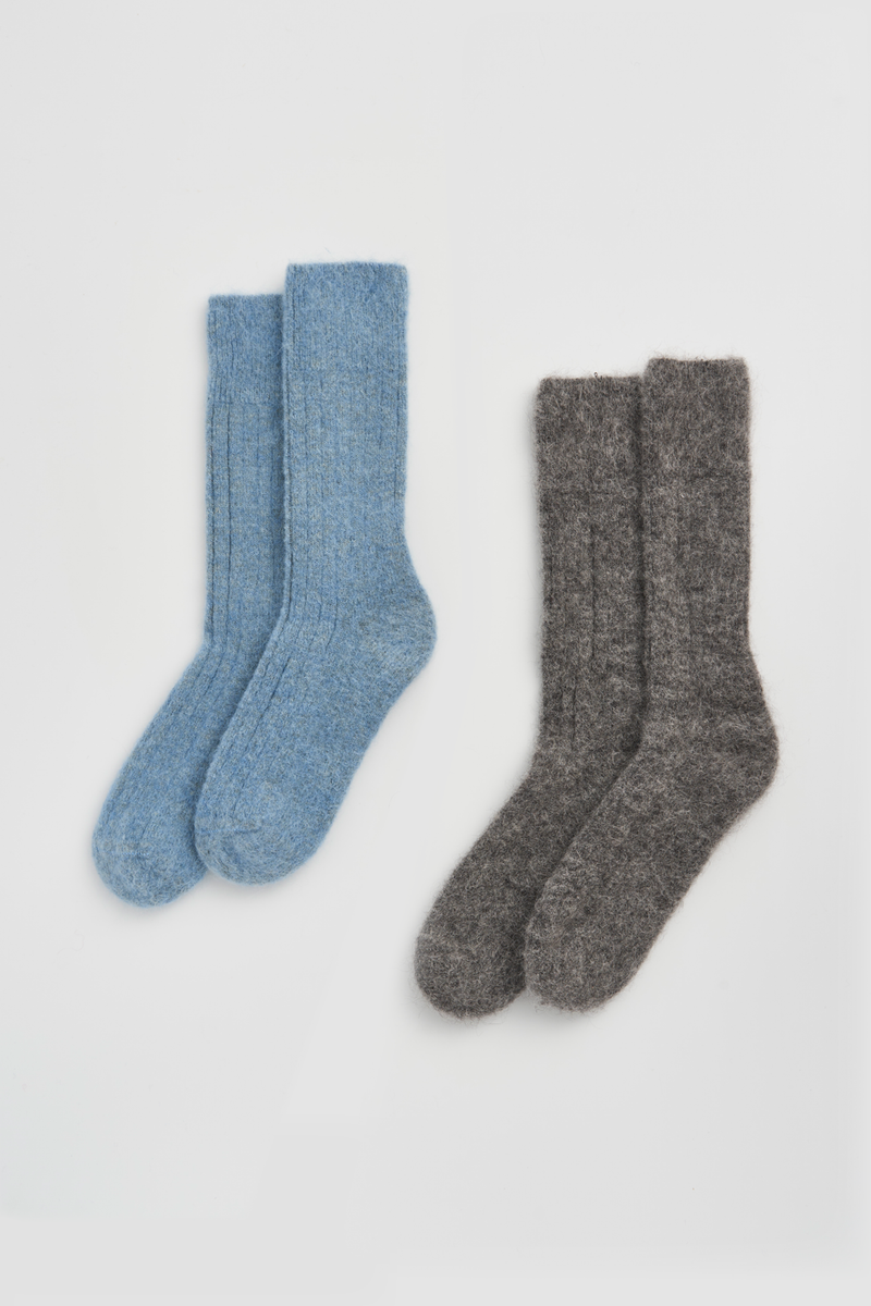 Two pairs of ribbed ultra soft alpaca bed socks, one blue and one grey, on a light grey background.