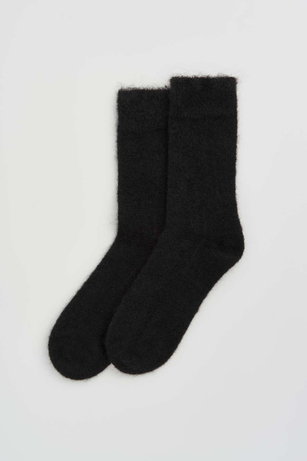 Pair of black ultra soft alpaca socks on a light grey background