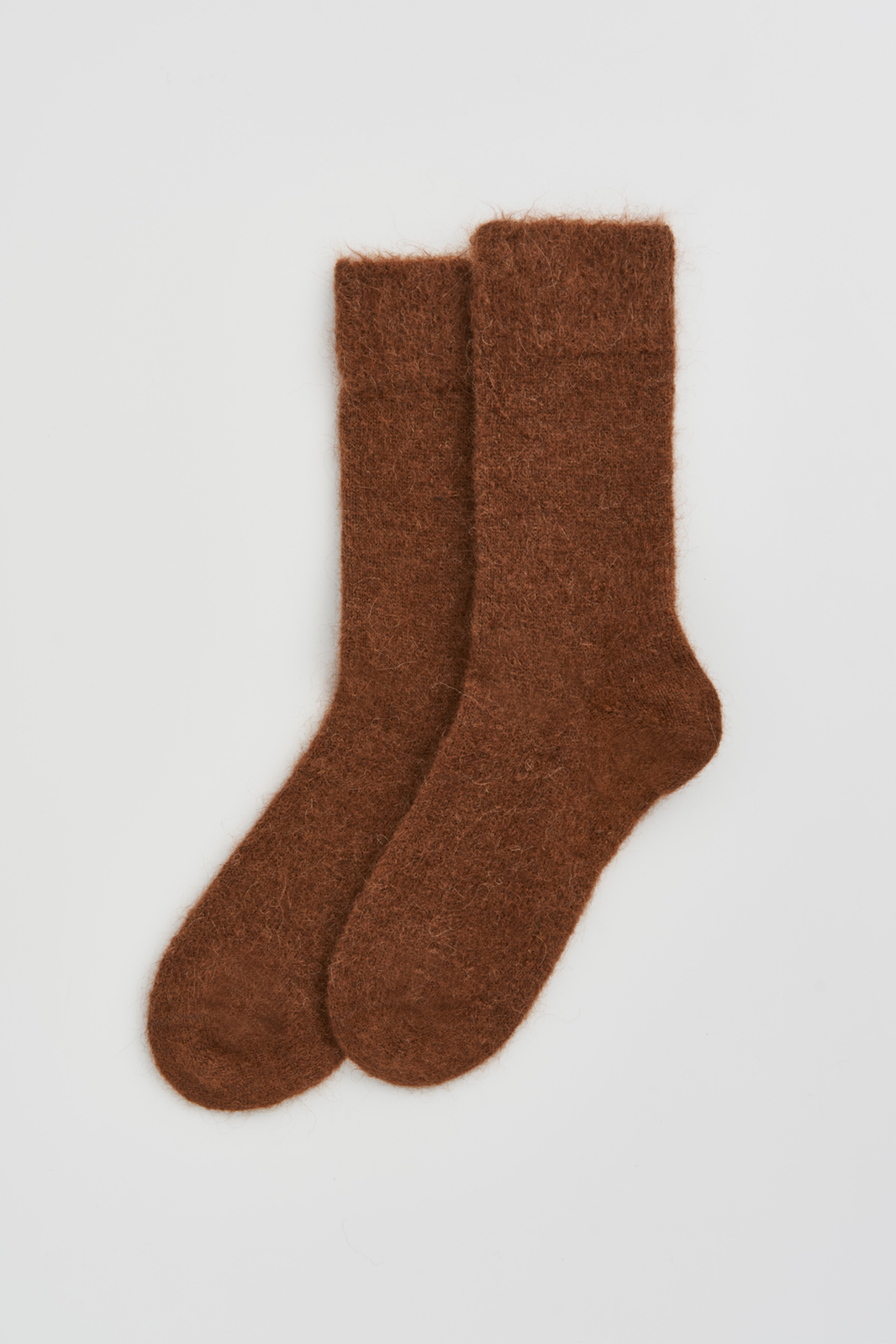 Pair of mid-brown ultra soft alpaca socks on a light grey background