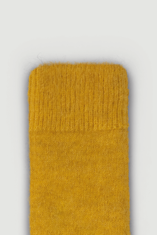 Close-up of the top of a mustard yellow calf length ultra soft alpaca sock