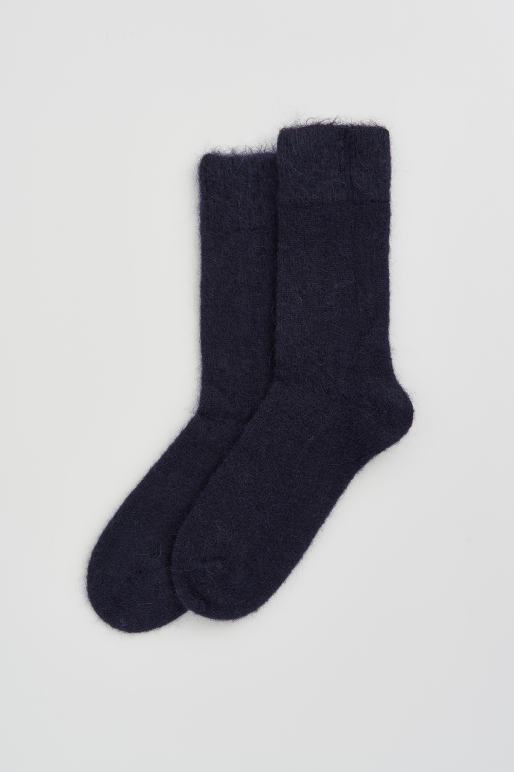 Pair of navy ultra soft alpaca socks on a light grey background