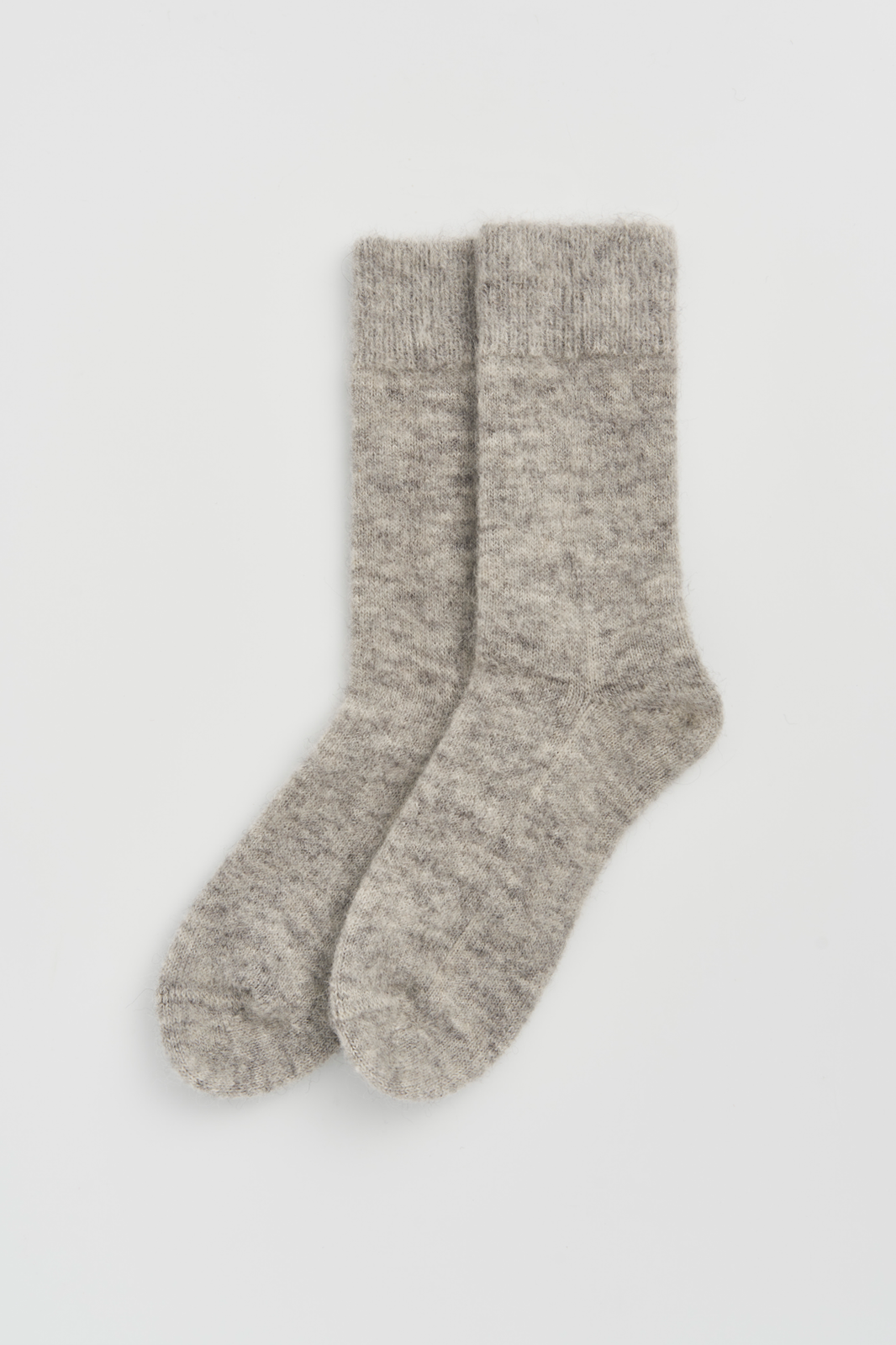 Pair of grey ultra soft alpaca bed socks on a light grey background
