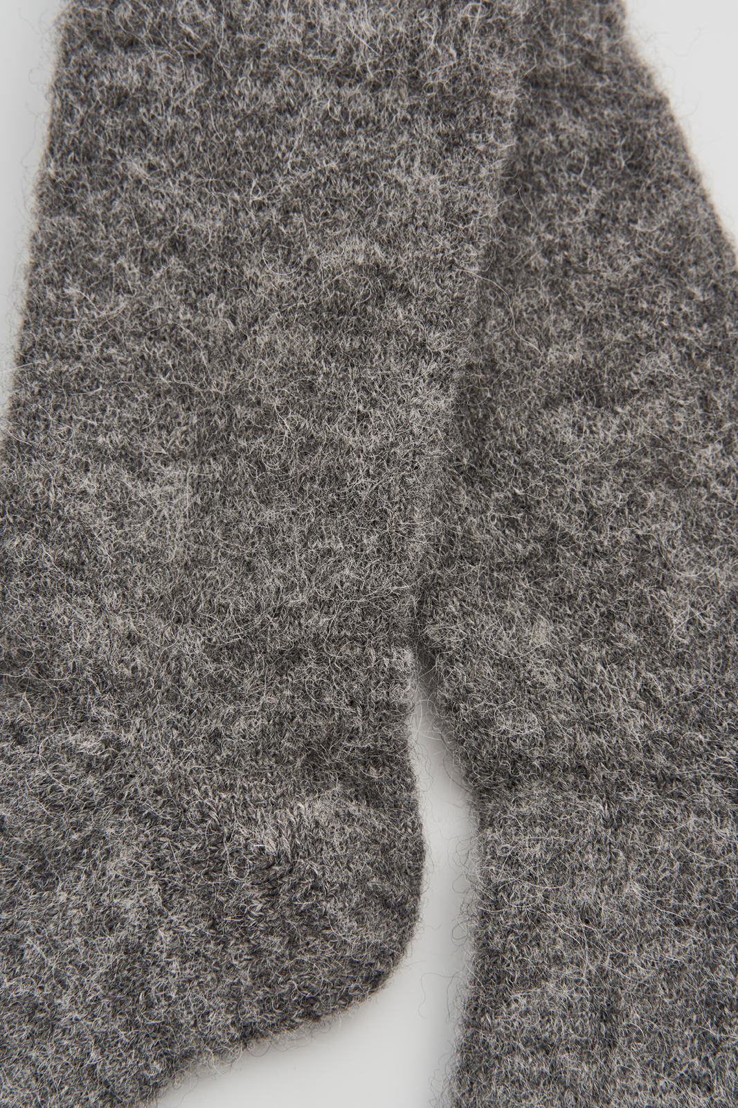 Close-up of a pair of grey ultra soft alpaca bed socks on a white background