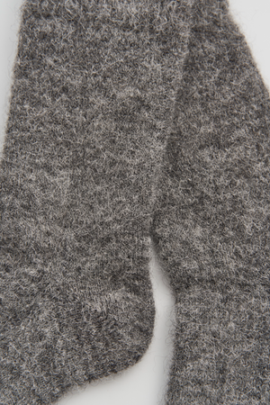 Close-up of a pair of grey ultra soft alpaca bed socks on a white background