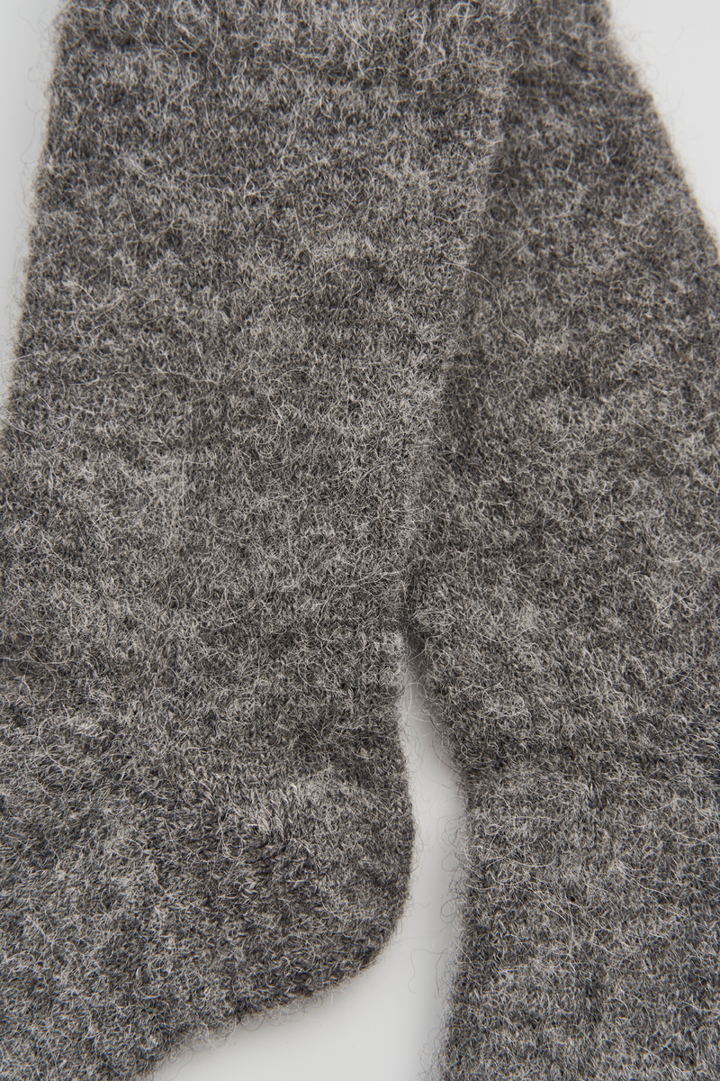 Close-up of a pair of grey ultra soft alpaca bed socks on a white background