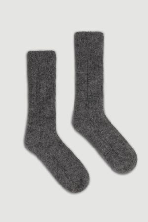 Pair of dark grey ultra soft alpaca ribbed bed socks on a light grey background