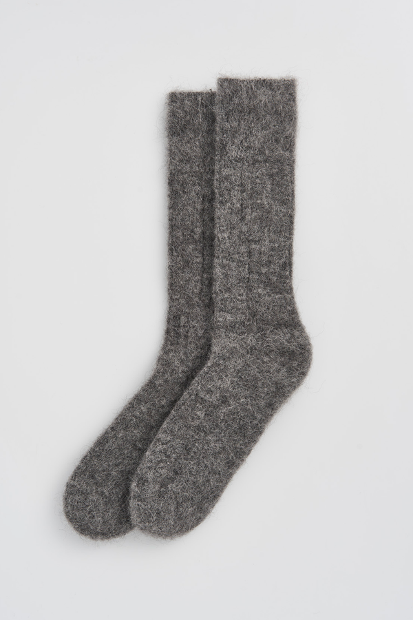 Pair of grey ultrasoft alpaca ribbed bed socks on a light grey background