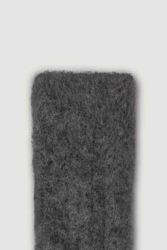 Close-up of the top of a dark grey ultra soft alpaca ribbed bed sock on a light grey background