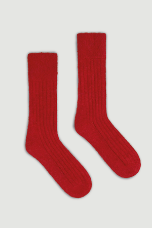 Pair of red ultra soft alpaca ribbed bed socks on a light grey background