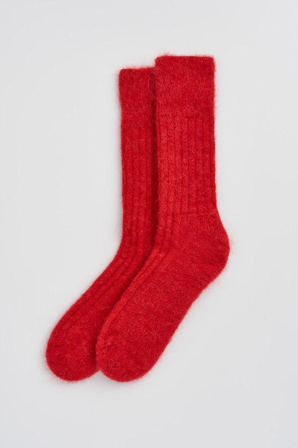 Pair of red ultra soft alpaca ribbed bed socks on a light grey background
