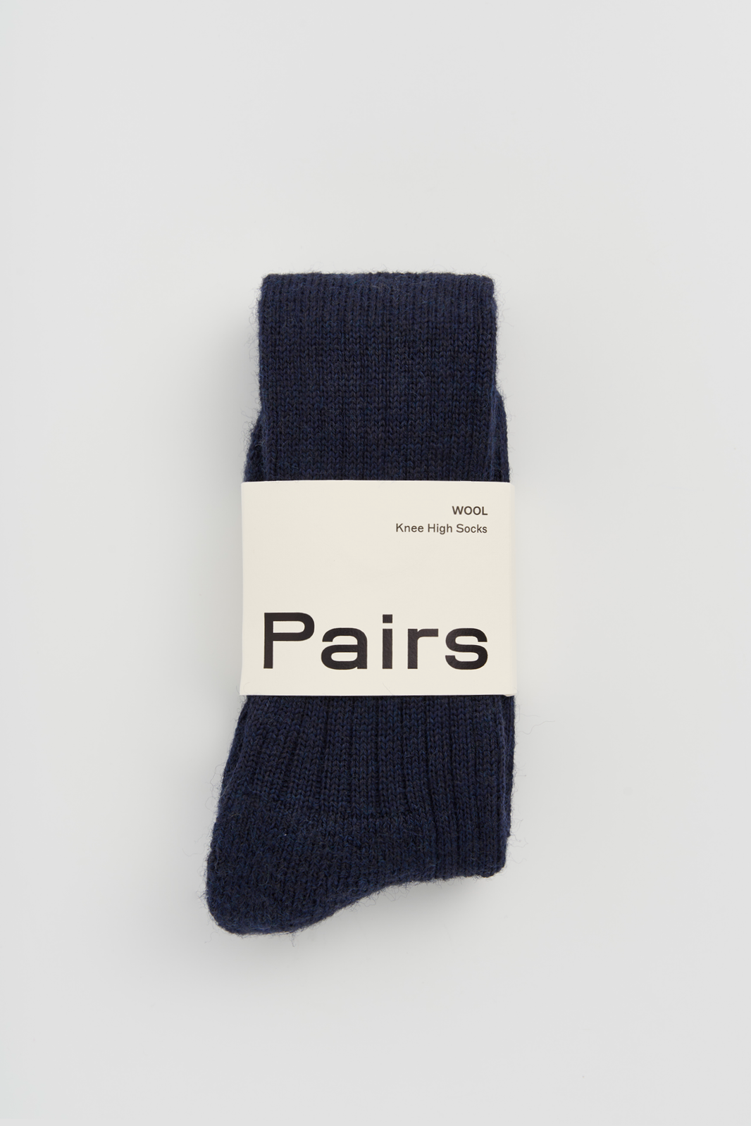 Navy wool knee high sock with a 'Pairs' packaging band on a light grey background