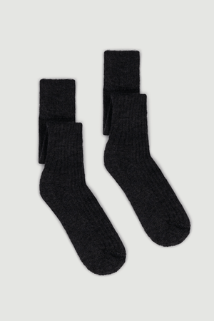 Pair of dark grey wool knee high socks on a light grey background