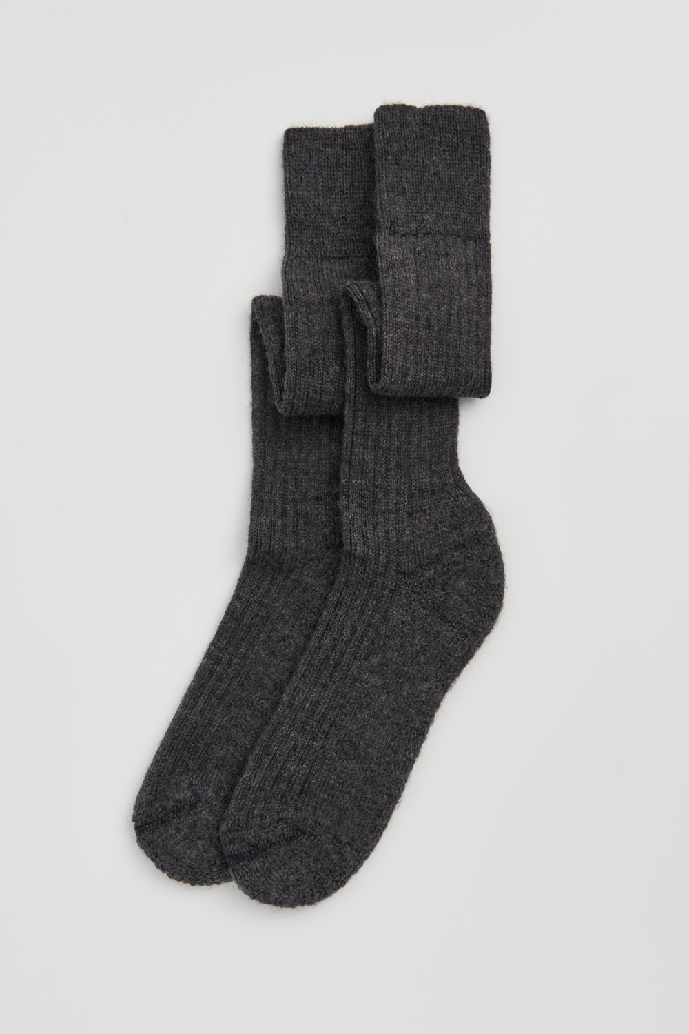 Pair of dark grey wool knee high socks on a light grey background