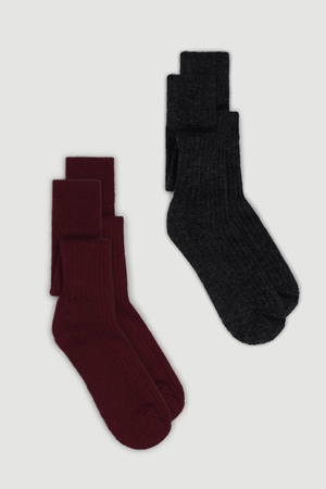 Two pairs of wool knee high socks, one maroon and one  dark grey on a white background.