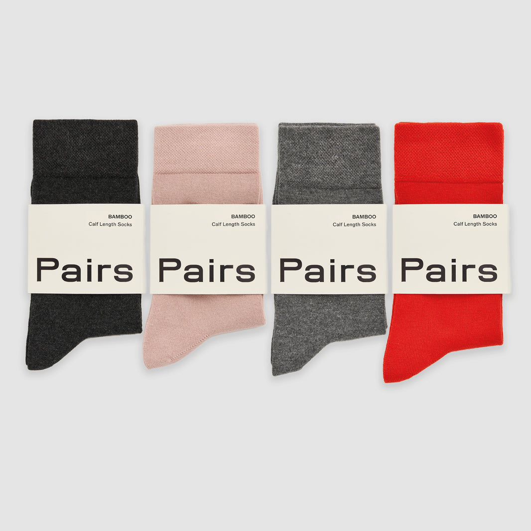 Four pairs of bamboo socks in black, pink, gray, and red with 'Pairs' label on a white background